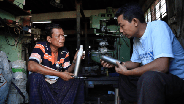 A Proximity Designs engineer speaks to machinist about a prototype of the Lotus solar irrigation pump.